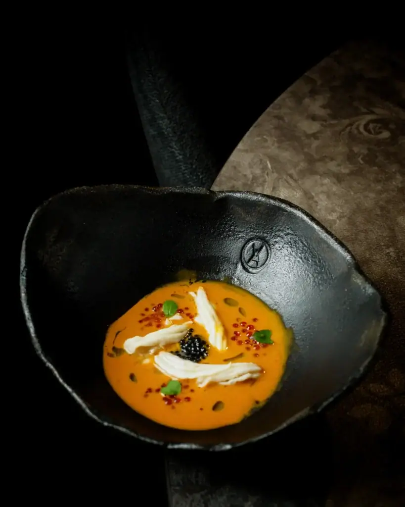 Crema amb caviar servida en un bol negre al VIA